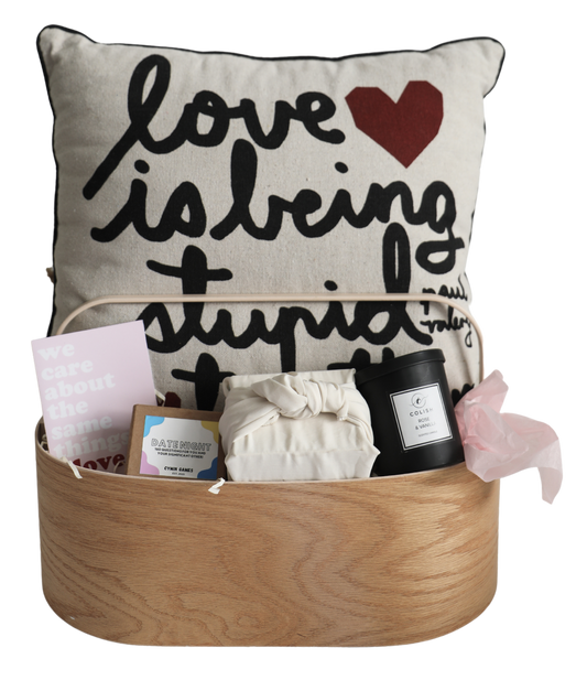 Experience our 'Love Language' Hamper, a beautiful selection to celebrate your love. With a comfy cushion, scrumptious brownies, a candle, a touching card, and a delightful game, this hamper is perfect for anything ranging from a date night to an anniversary dinner.