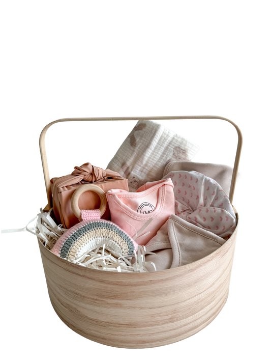 A thoughtful blend of treats for both baby and mama. This chic hamper features essentials for the newest addition to the family, including a soft baby cap, an adorable pink onesie, a stylish bib, and a practical burp cloth – all in delightful pink hues.